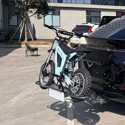 Off road electric dirt bike secured on hitch mounted carrier rack attached to SUV