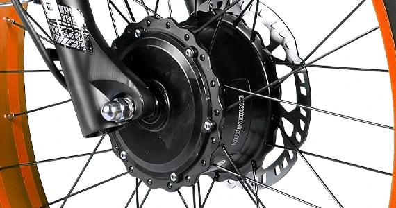 Close-up of the Tuttio Adria26 front hub motor with black motor housing, front fork connection, spokes, orange rim edge, and disc brake rotor visible