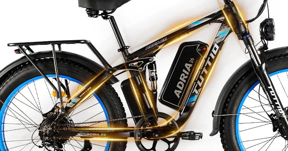 Side profile of the gold Tuttio Adria26 showing the full frame, battery box, rear rack, blue-rim fat tires, front and rear fenders, and handlebar area