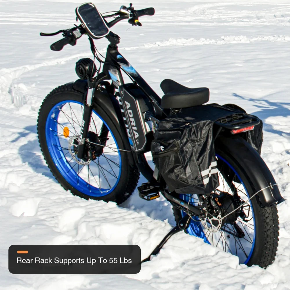 Tuttio Adria26 parked in snow from a rear side angle, showing the black frame, blue rims, rear cargo rack, side bag, rear fender, and rack capacity callout