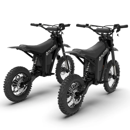 Rear three-quarter view of two black TUTTIO electric dirt bikes, highlighting the rear suspension springs, chain drives, and seat design.