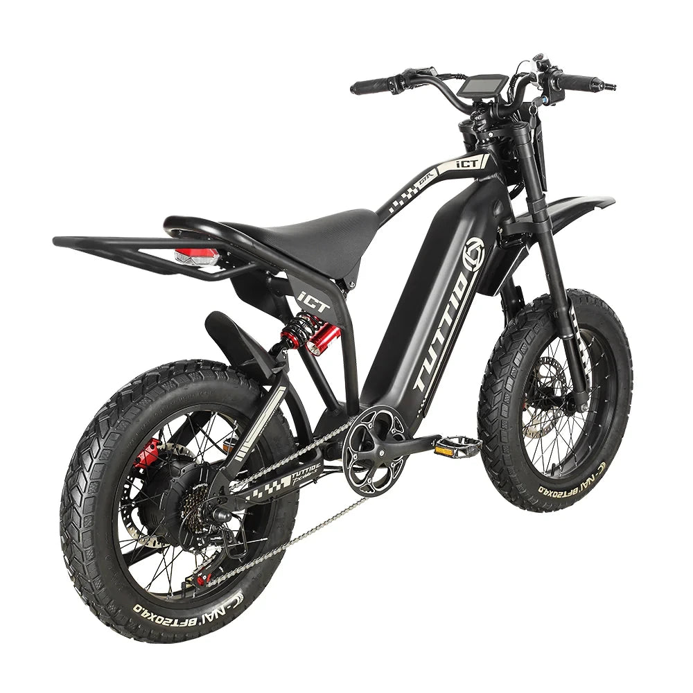 Studio shot on a clean white background displaying the right rear three-quarter angle of the black Tuttio ICT electric motorbike, highlighting its extended rear cargo rack, rear suspension, and rugged fat tires.