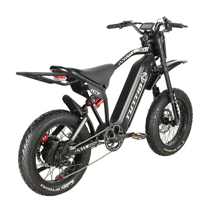 Studio shot on a clean white background displaying the right rear three-quarter angle of the black Tuttio ICT electric motorbike, highlighting its extended rear cargo rack, rear suspension, and rugged fat tires.