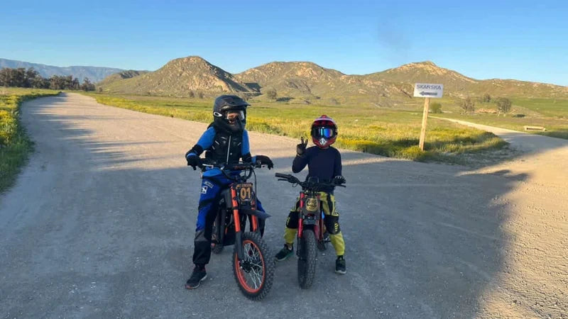 Two helmeted riders with the Tuttio Soleil01 and ARC-I on a mountain dirt road