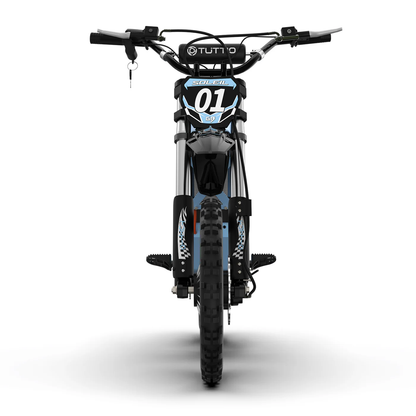 A direct head-on studio shot on a seamless white background displaying the front profile of the light blue Tuttio Soleil01 GB electric dirt bike, emphasizing its wide handlebars, prominent '01' racing plate, and narrow off-road stance.